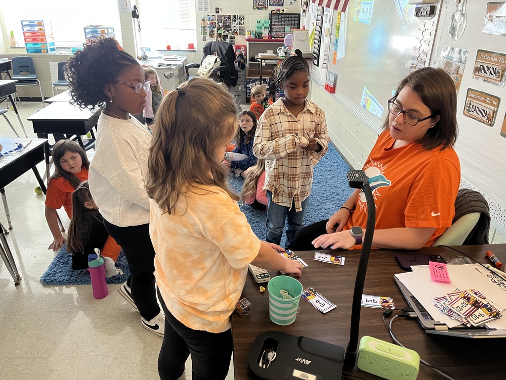 A teacher talks through math problems with her class. 