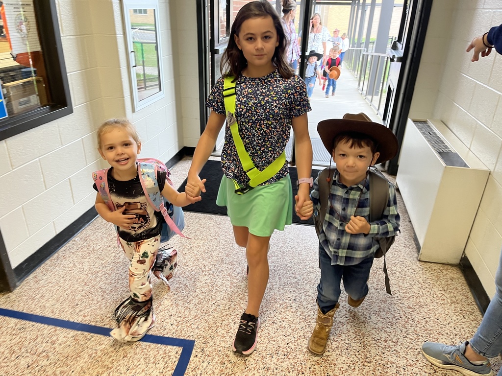Children in western wear pose for a photo.