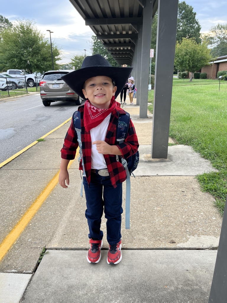 A child in western wear poses for a photo.