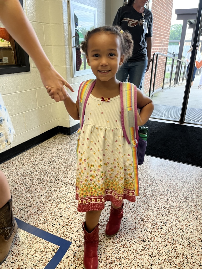 A child in western wear poses for a photo.