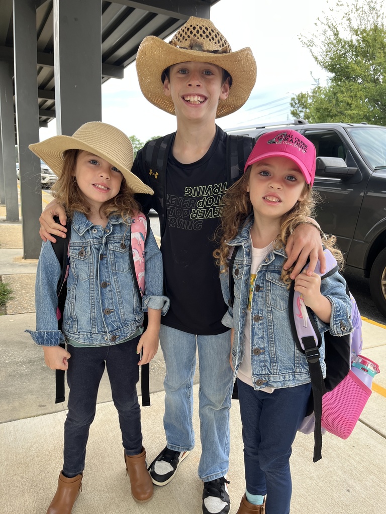 Children in western wear pose for a photo.