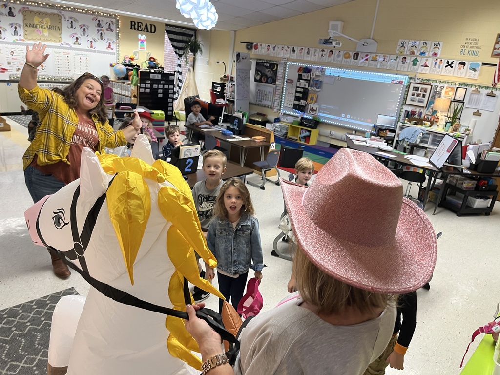 An administrator in a horse and rider costume interacts with children.