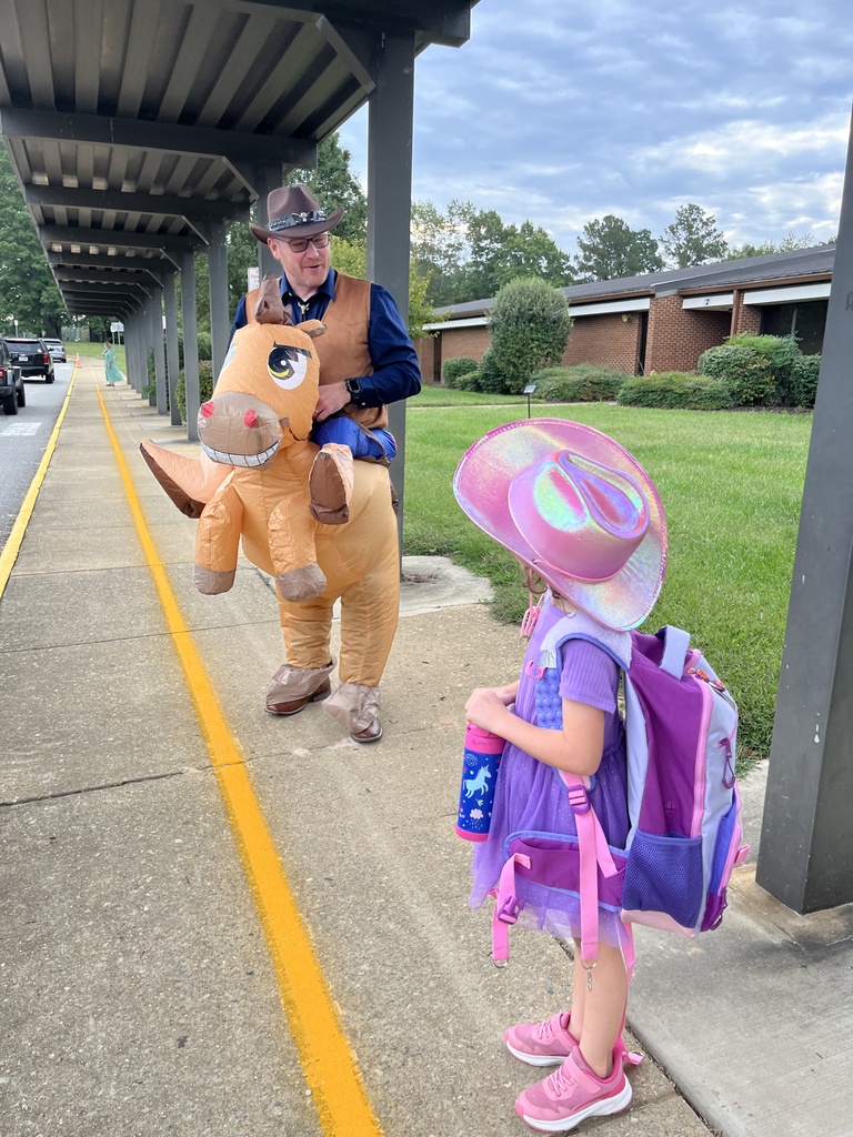 An administrator in a horse and rider costume interacts with a child.