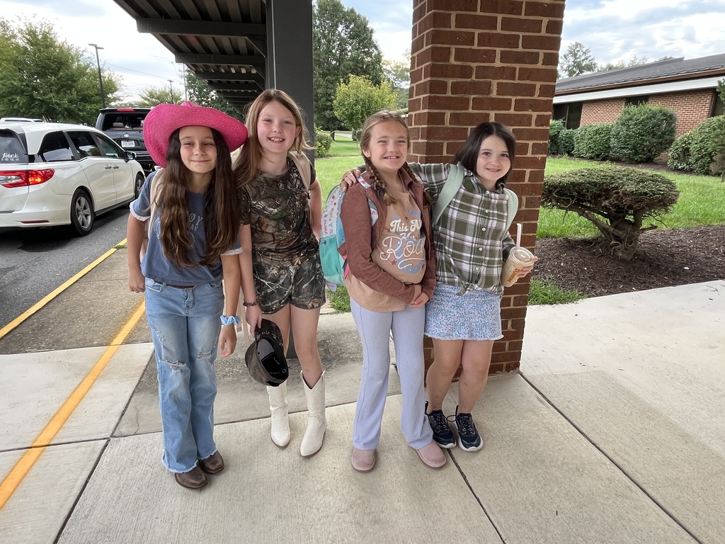 Children in western wear pose for a photo.