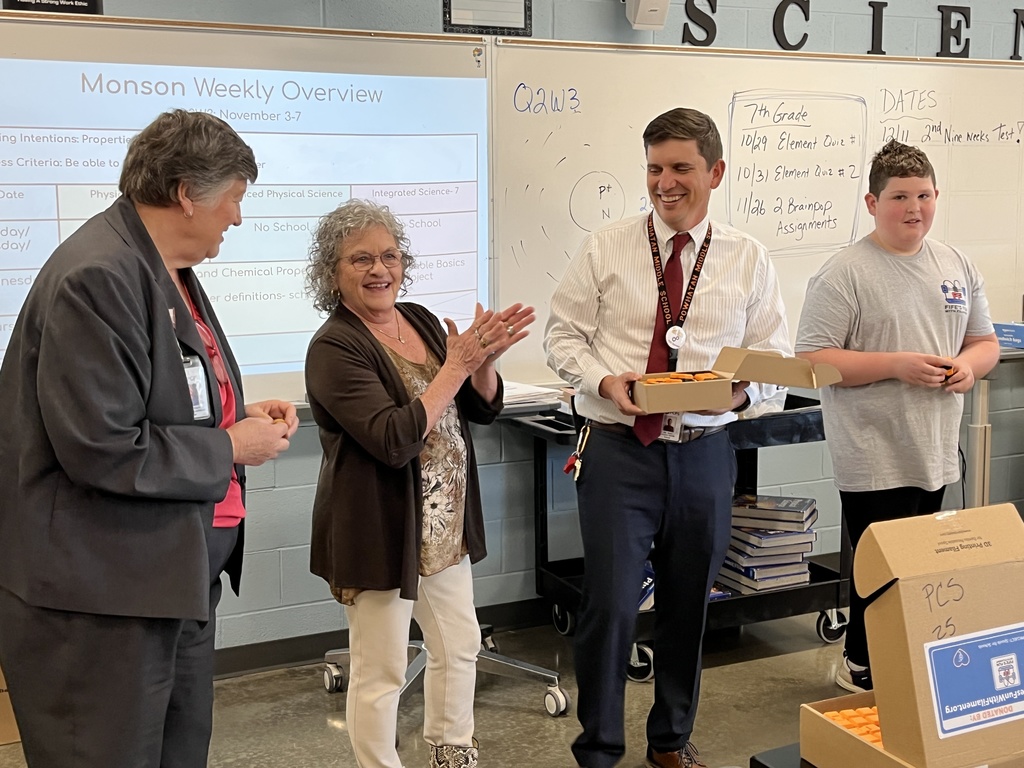 Three  adults and a student speak during a fidget spinner donation.