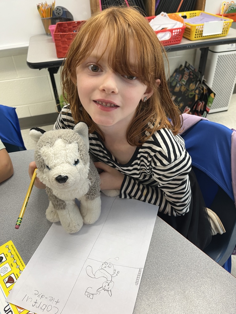 A student shows a stuffie she brought to school.