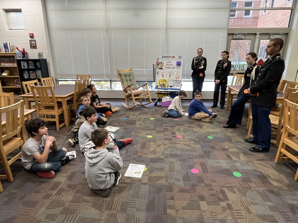 A group of students listen to a fire safety presentation given by JROTC cadets. 
