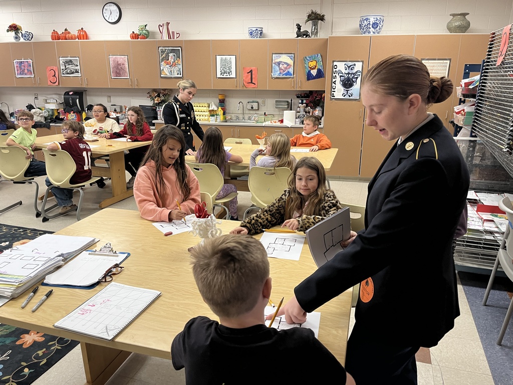 A group of students listen to a fire safety presentation given by JROTC cadets. 