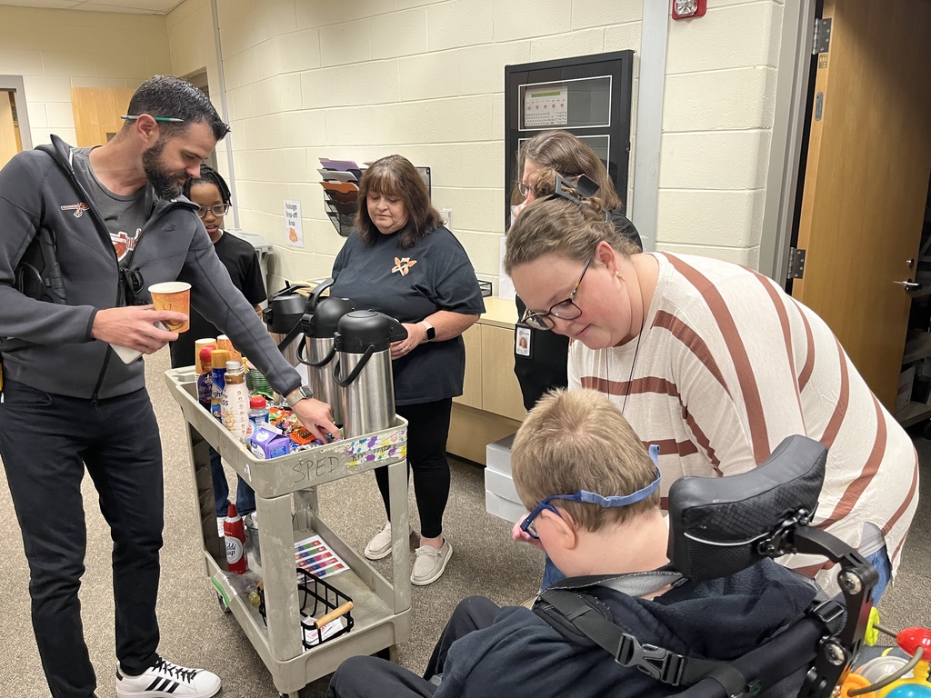 Students serve hot chocolate or coffee to school staff in a coffee train.