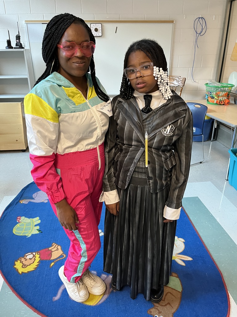 An adult and  child pose for a photo at a fall festival.
