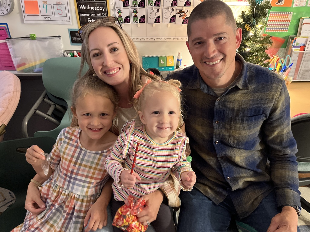Two adults and two children pose for a photo at a fall festival.