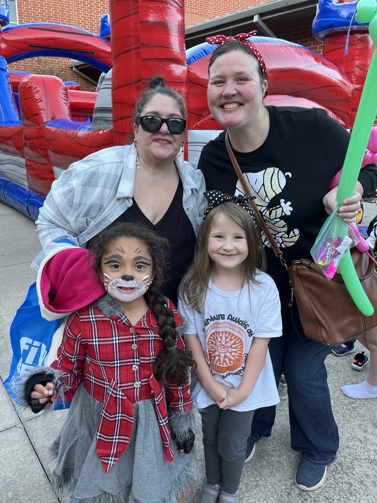 Two adults and two children pose for a photo at a fall festival.