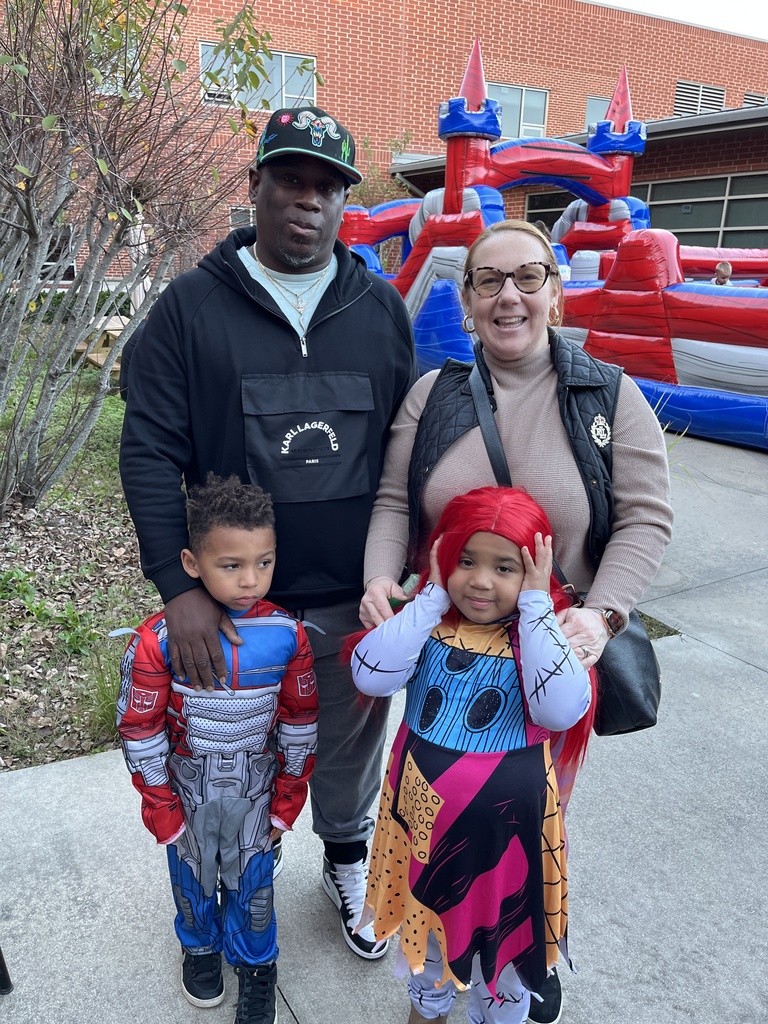 Two adults and two children pose for a photo at a fall festival.