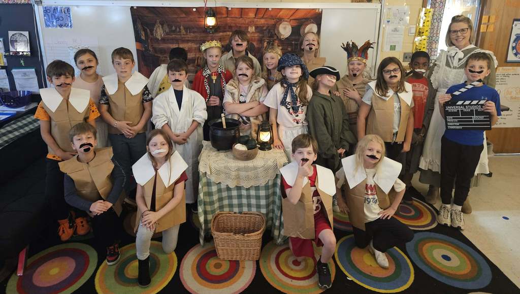 A large group of students in costume pose for a group photo. 