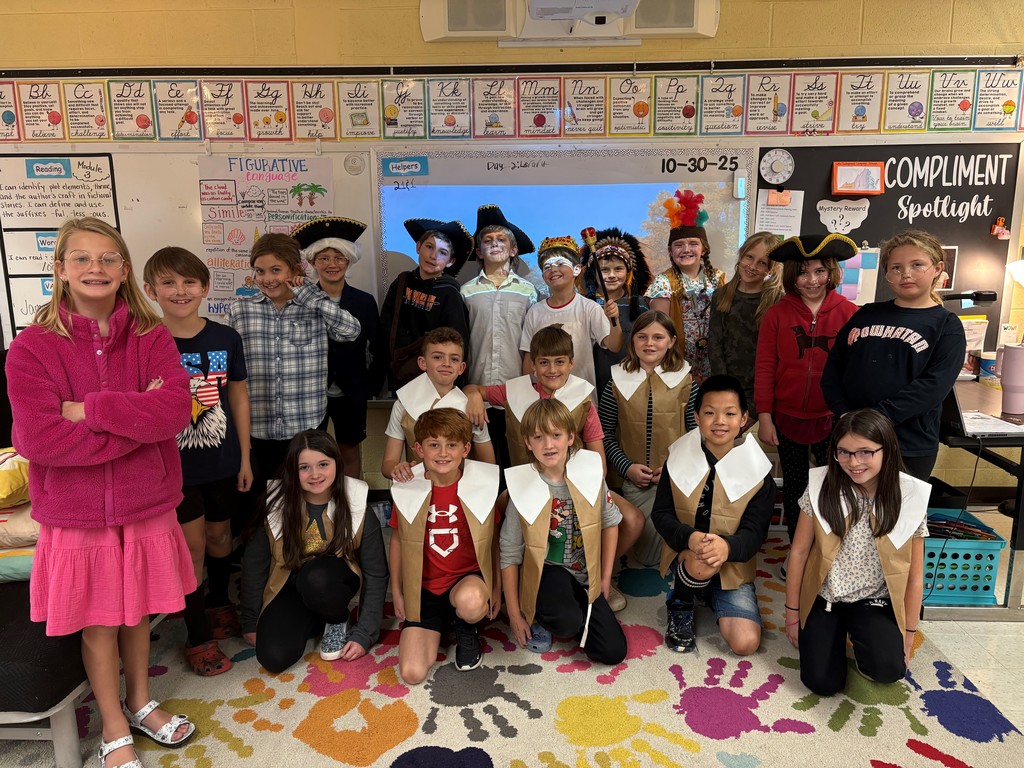 A large group of students in costume pose for a group photo.