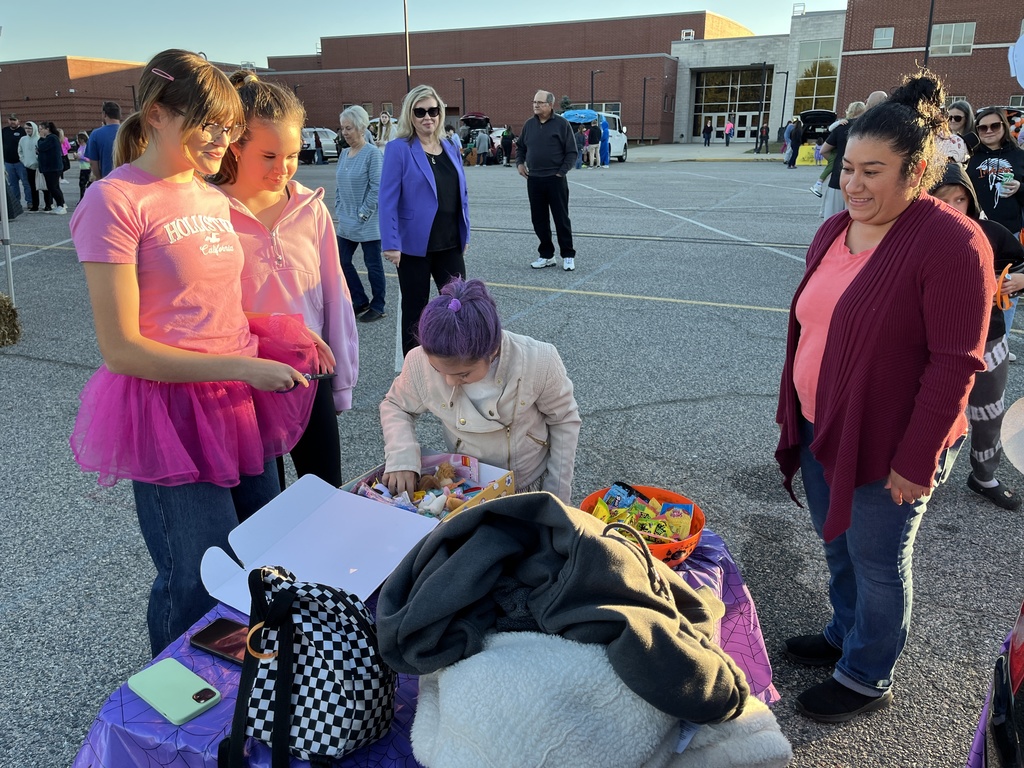 A child gets candy  at a trunk or treat station.