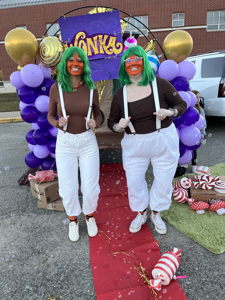 A group of teens pose for a photo at a trunk or treat event.