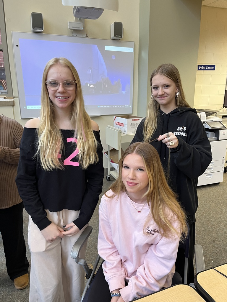 Three teens pose for a photo at a high school spookfest. 
