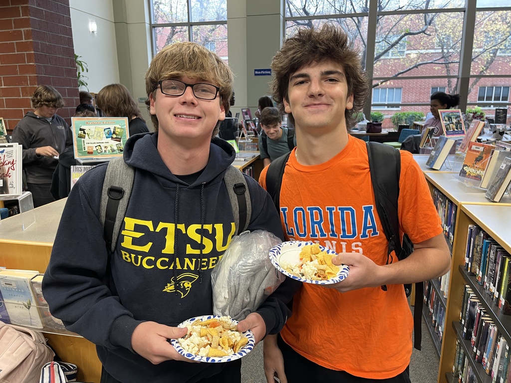 Two  teens pose for a photo at a high school spookfest. 