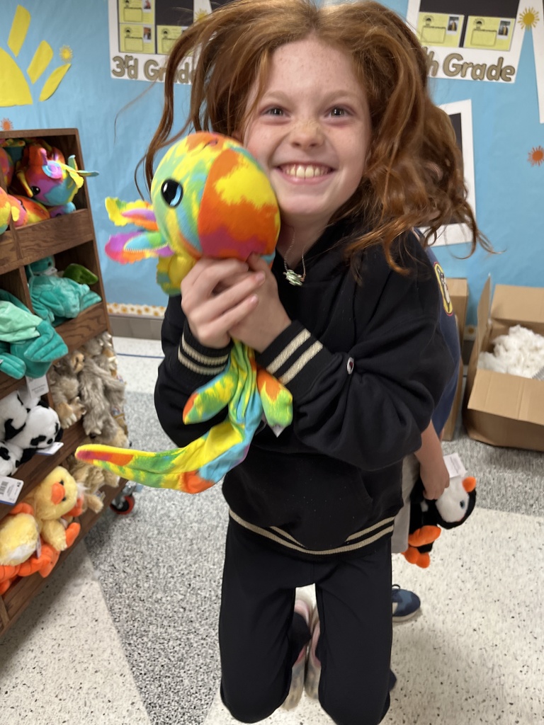 A child poses with a stuffed animal earned in a fundraiser.
