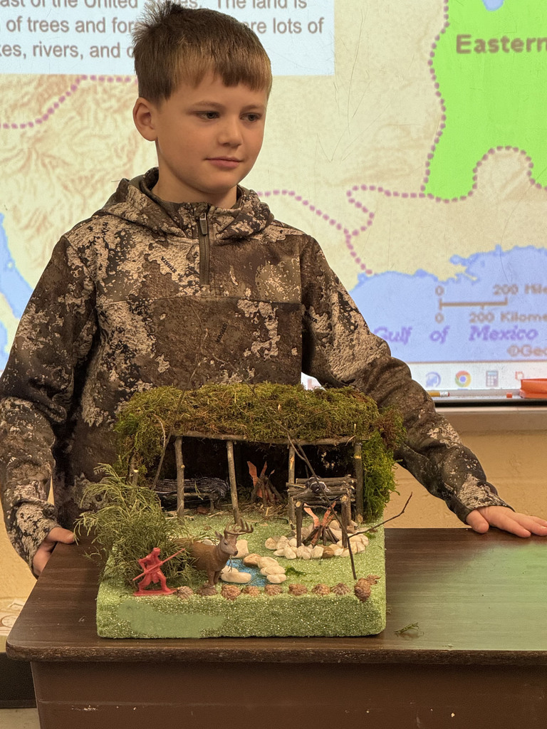 A child presents work at a class's Native American Museum.