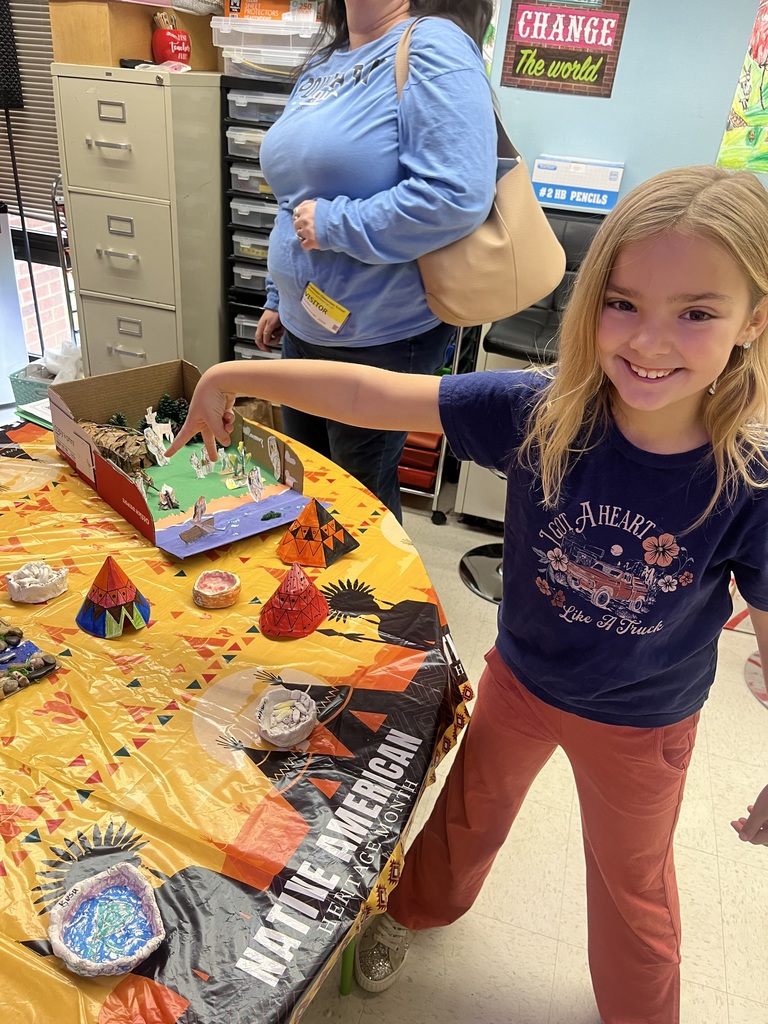 A child poses for a photo at a class's Native American Museum.