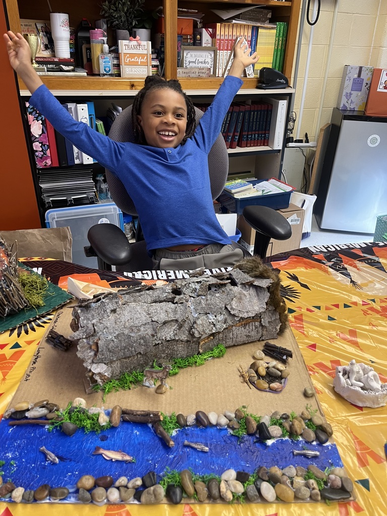 A child poses for a photo at a class's Native American Museum.
