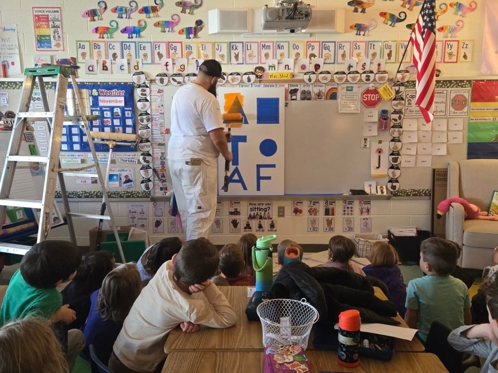 A painter talks to kindergarteners about painting and shows them the tools of his trade. 