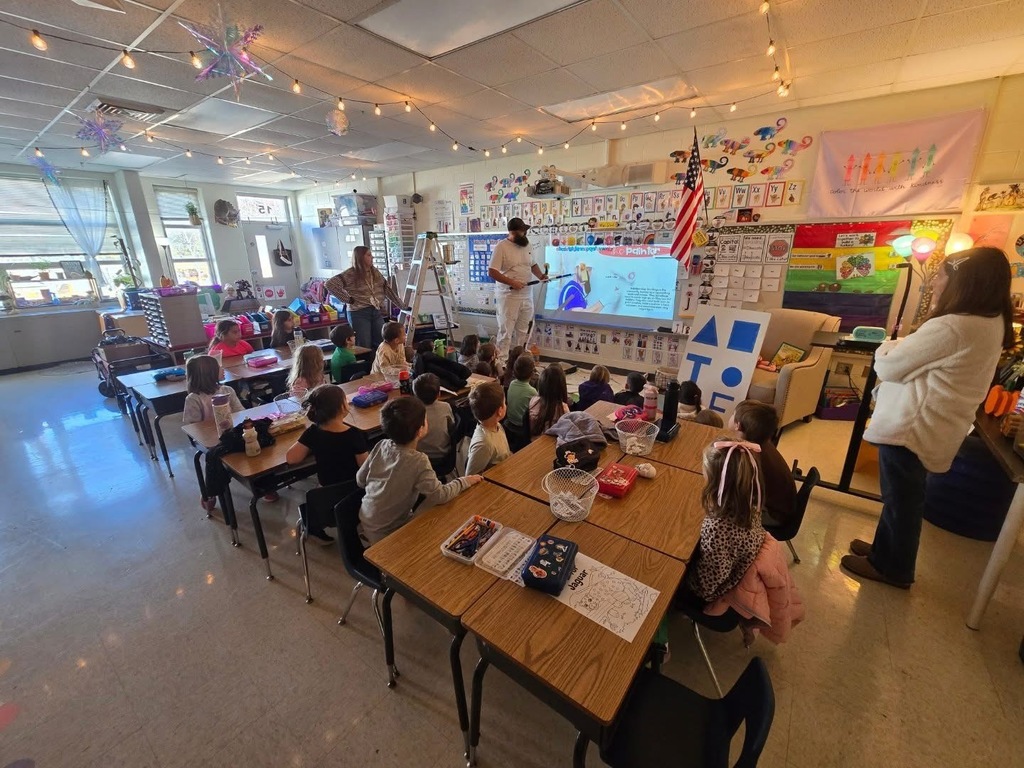 A painter talks to kindergarteners about painting and shows them the tools of his trade. 