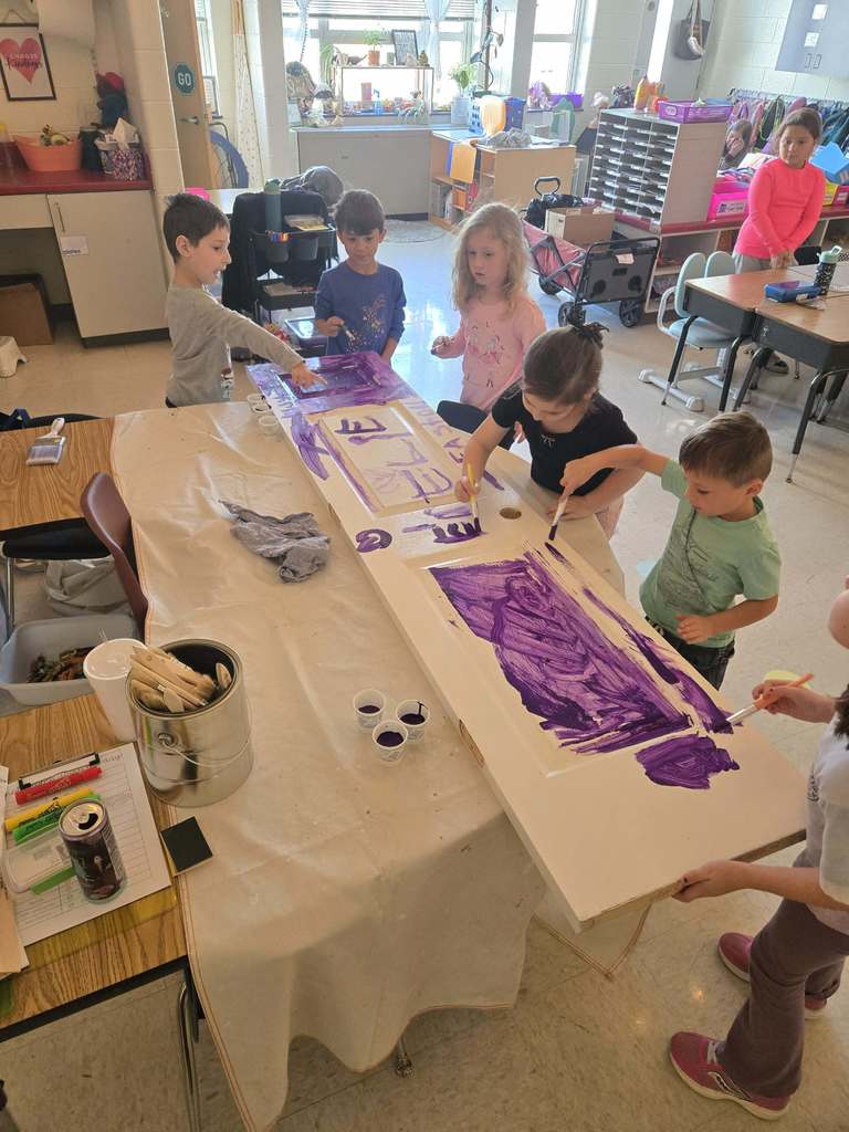 Students paint a pantry door in class. 