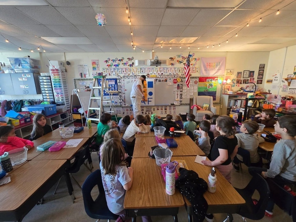 A painter talks to kindergarteners about painting and shows them the tools of his trade. 