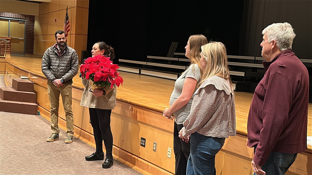 A teacher is surprised with an award and speaks to the room.