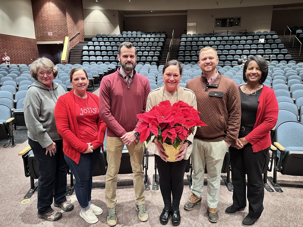 A group of men and women pose for a photo in an auditorium.