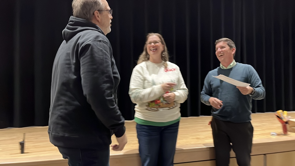 A man who has been named teacher of the year is celebrated by his principal and assistant principal.