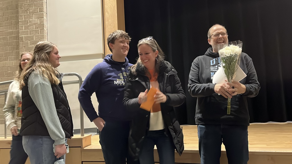 A man who has been named teacher of the year is celebrated by his family members. 