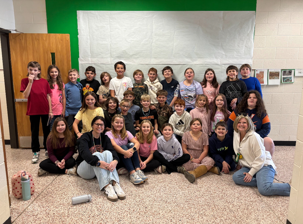 Two adults and a group of students pose for a photo.