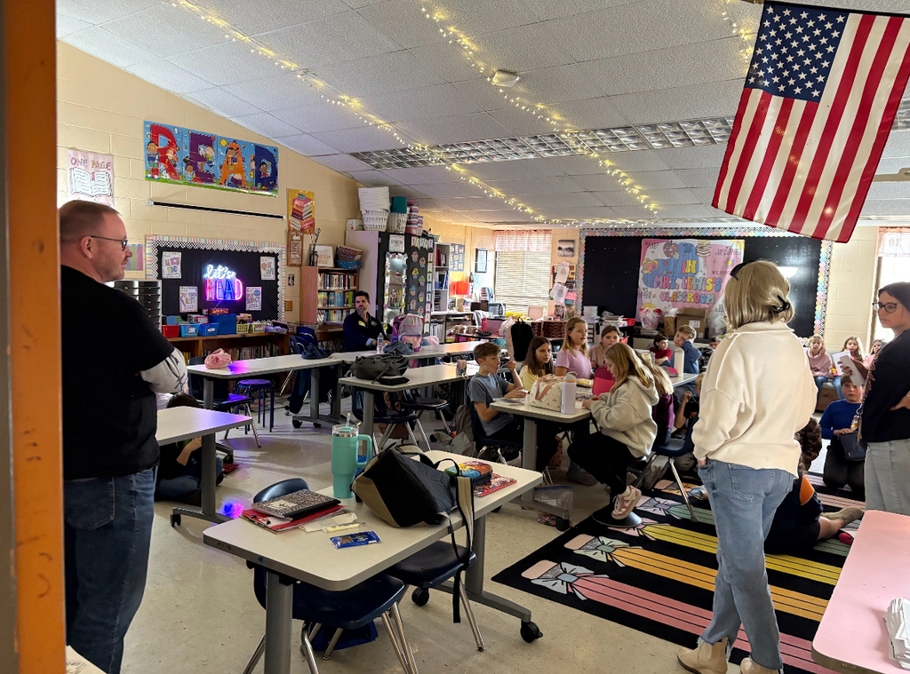 Adults talk to students in an elementary school book club.