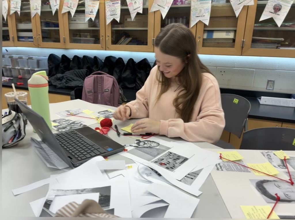A student in a Forensic Science class creates an evidence board for her semester exam.