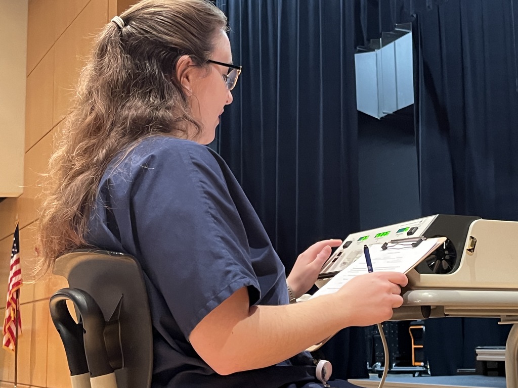 A college student conducts a hearing test at a high school.