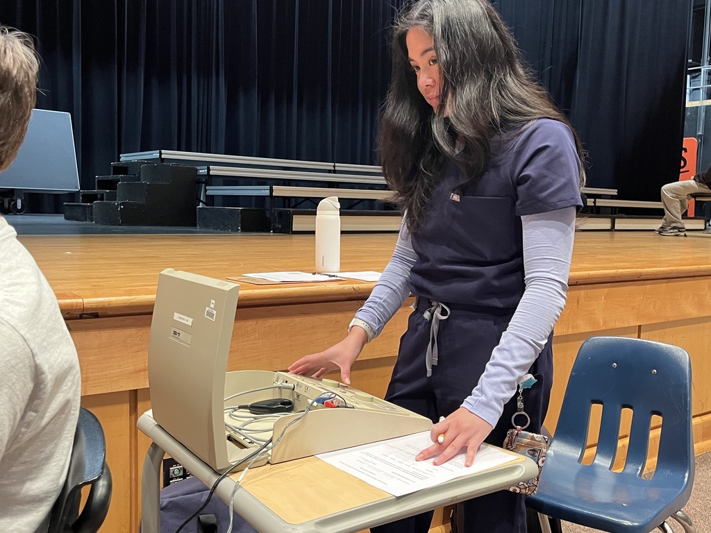 A college student conducts a hearing test at a high school.