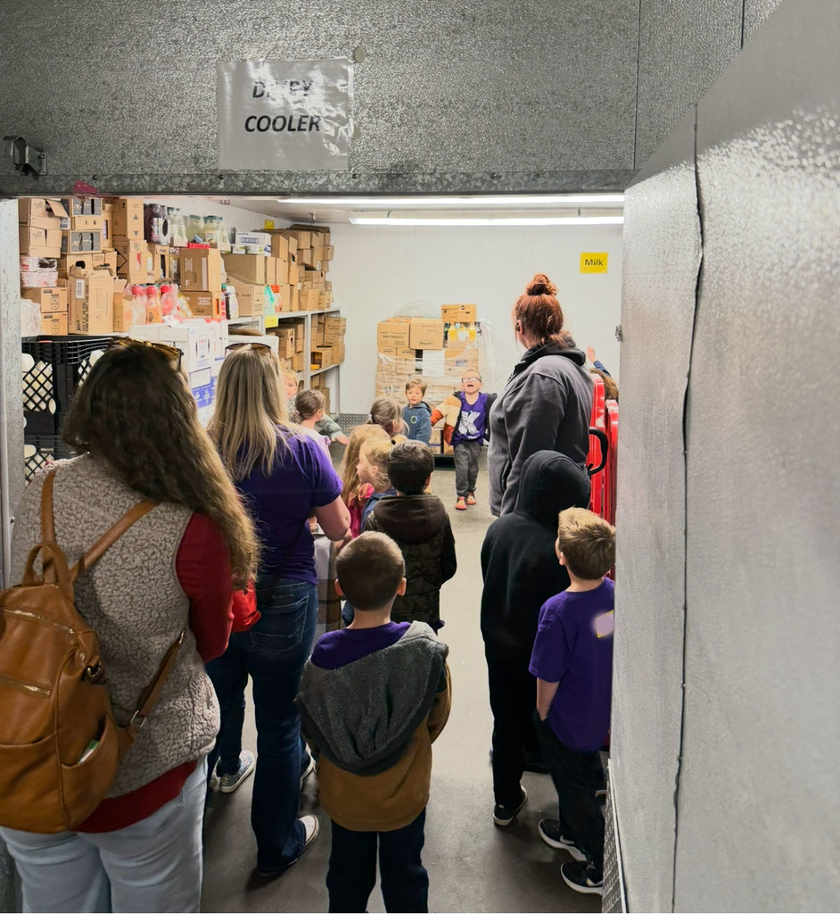 A kindergarten class  takes a tour of a walk-in freezer.