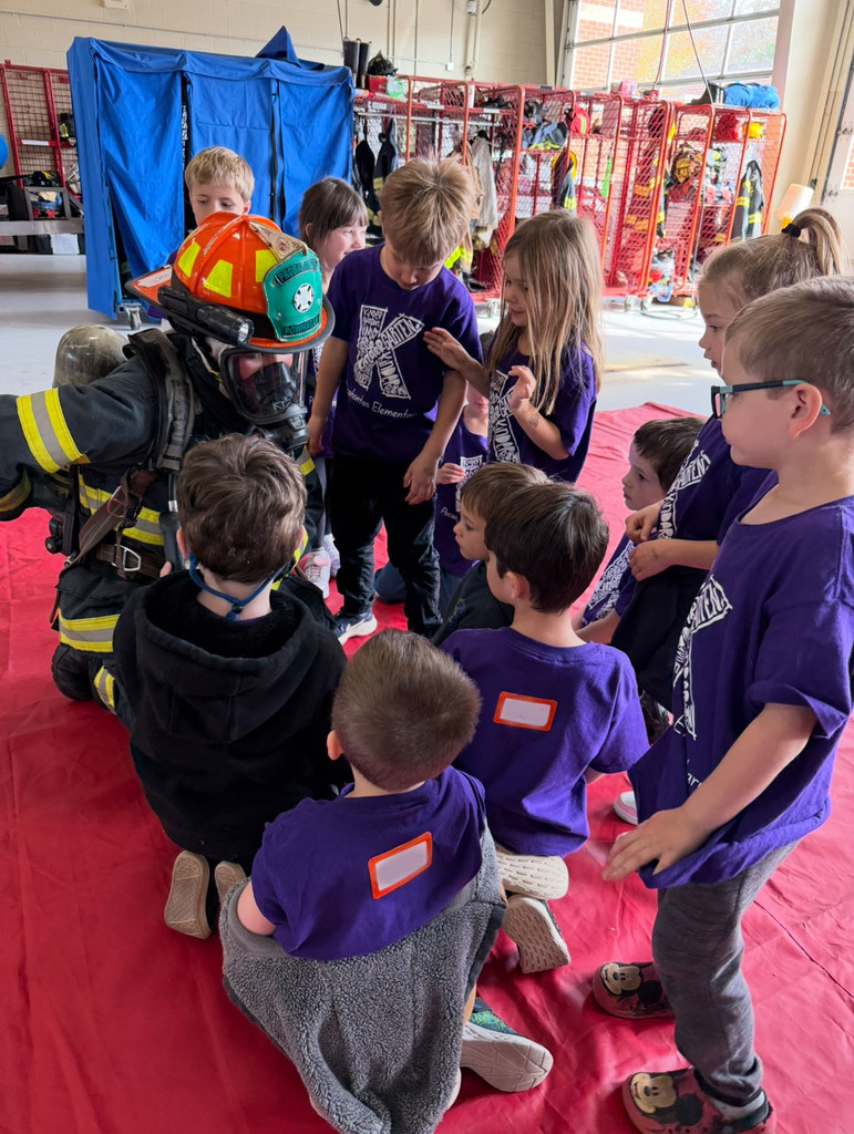 A kindergarten class takes a tour of a fire company. 