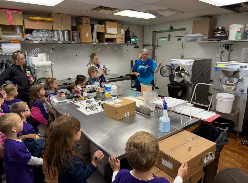 A kindergarten class  takes a tour of an ice cream store.