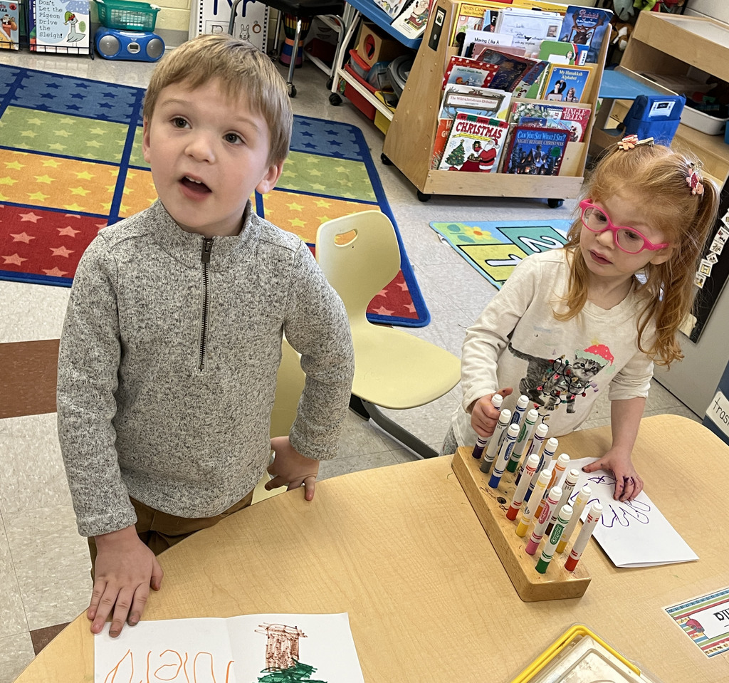 Preschoolers make a card for their student teacher.