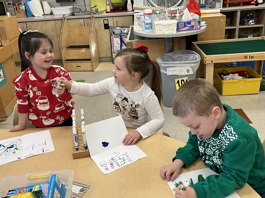 Preschoolers make a card for their student teacher.