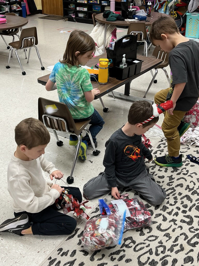Children make fabric wreaths in class. 