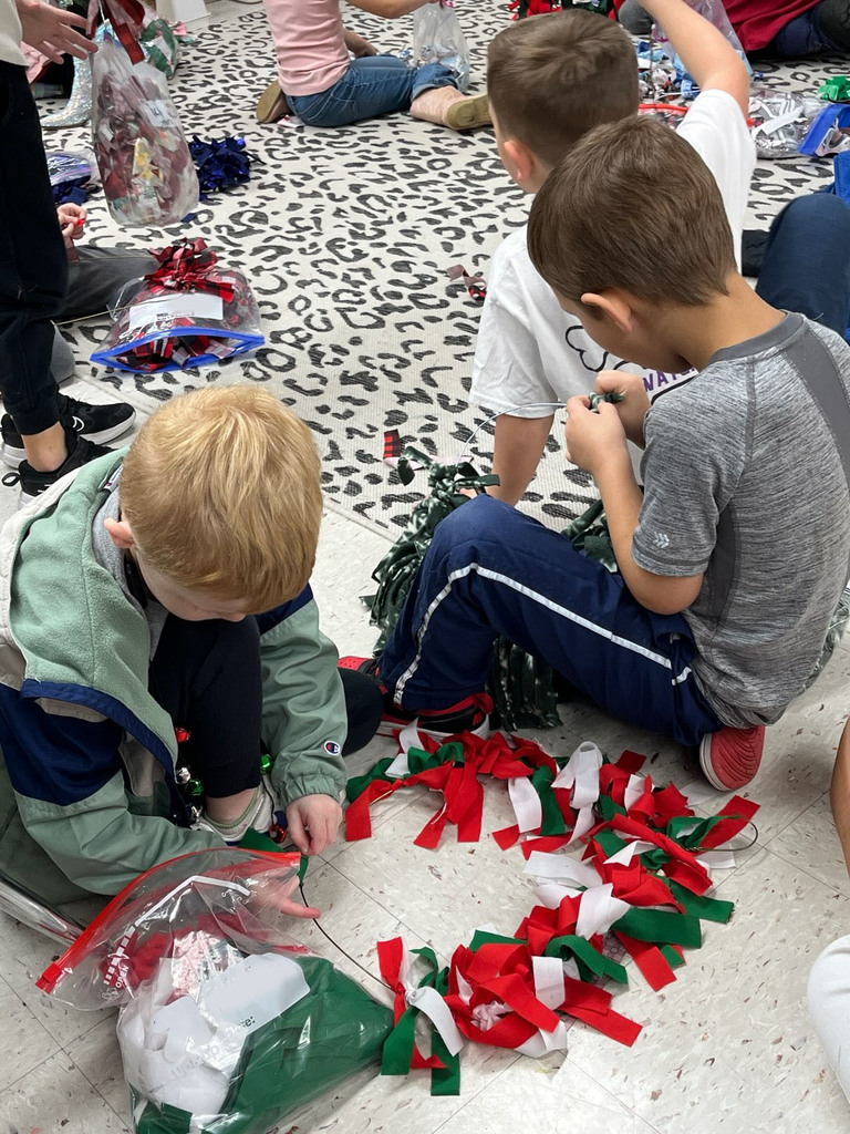 Children make fabric wreaths in class. 
