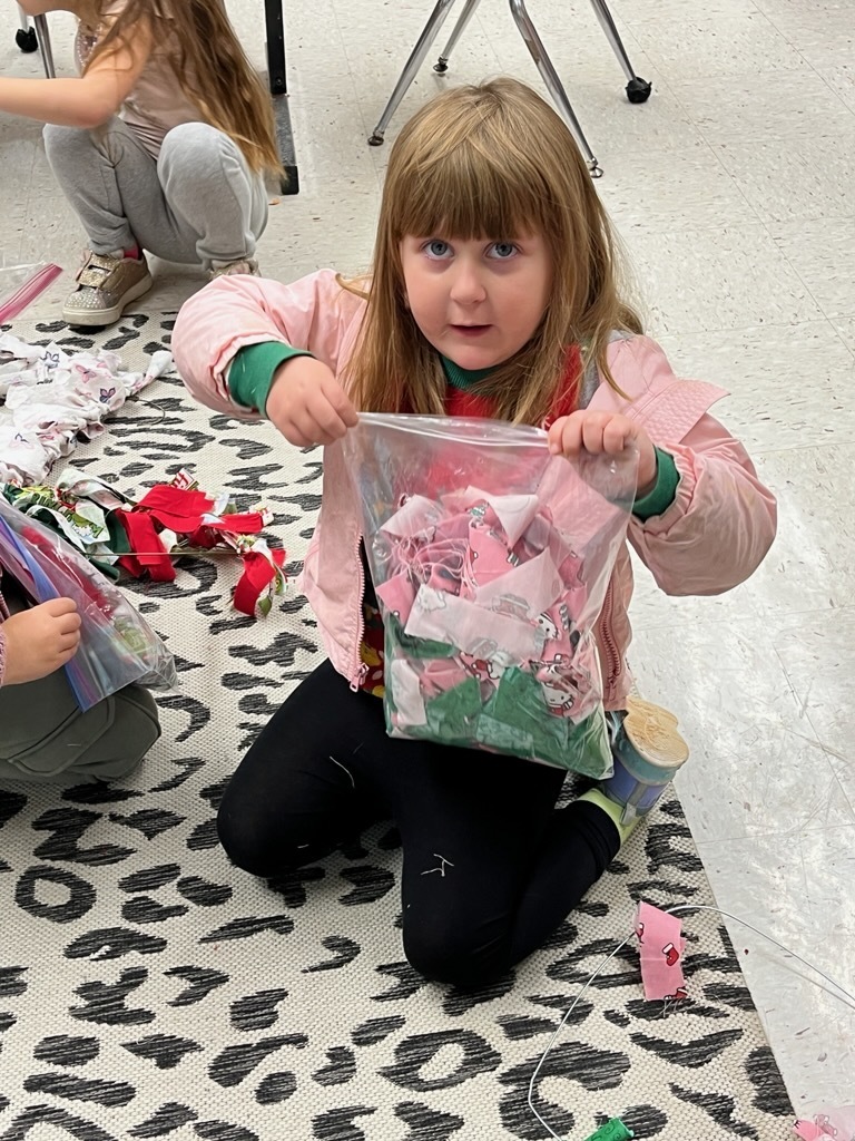 A child makes a fabric wreath in class. 