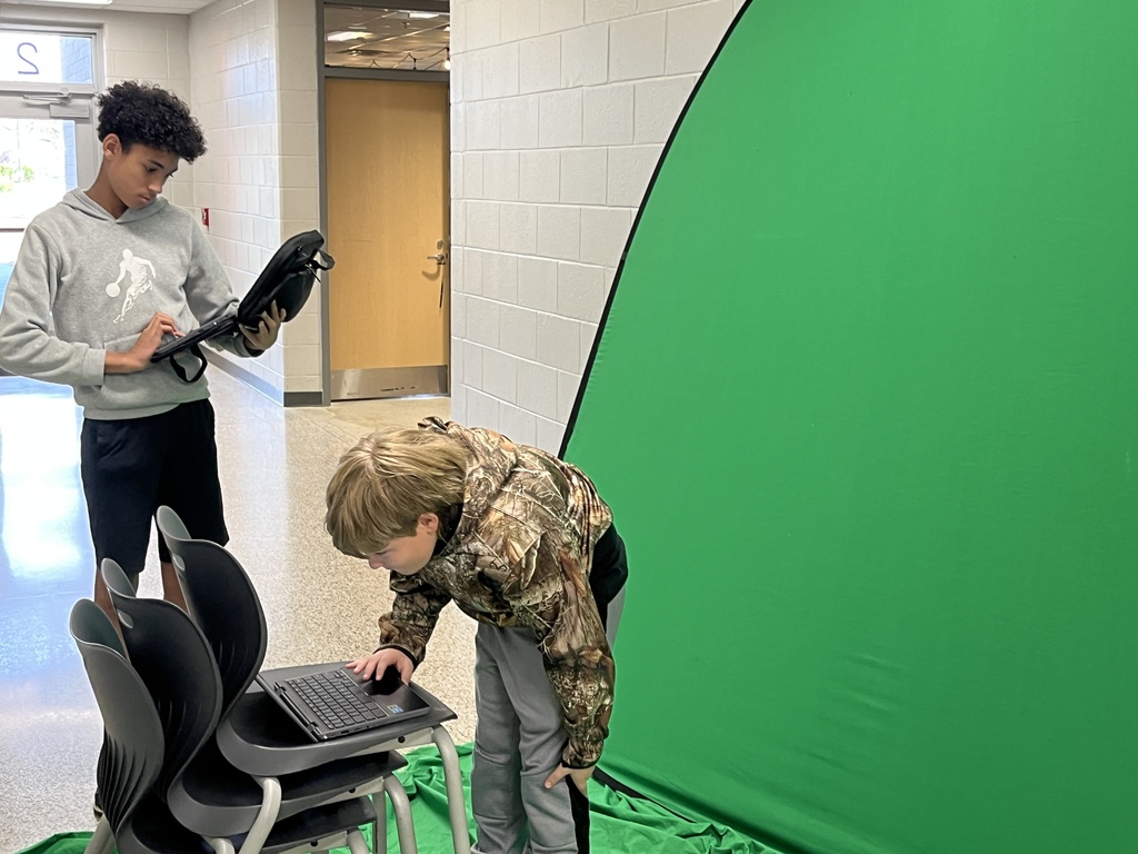 Students work with a green screen as part of a weather forecast production unit. 