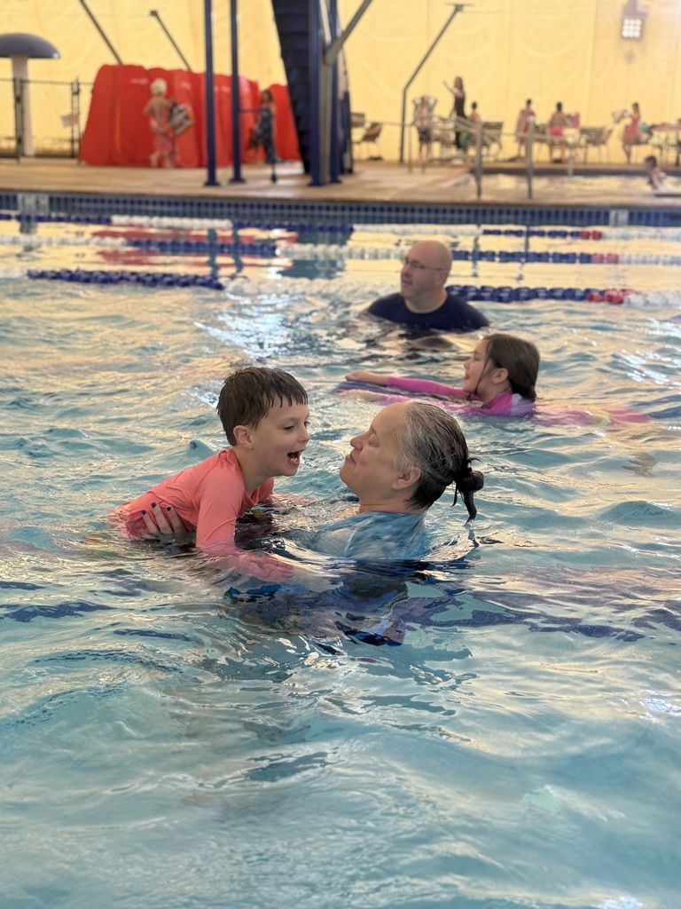 Instructors help children learn to swim.